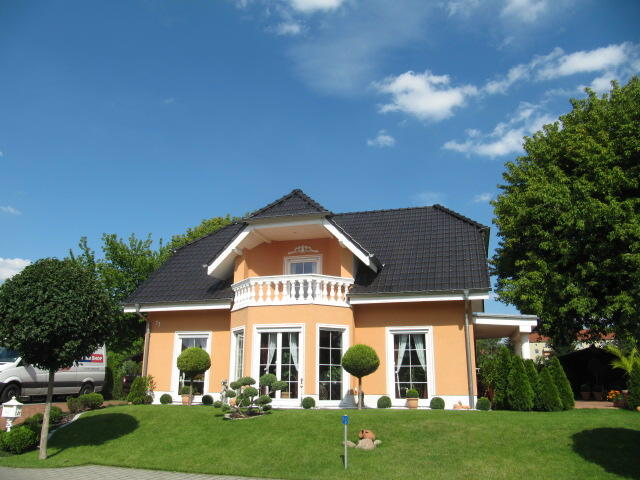 Haus mit Krüppelwalmdach und Erker